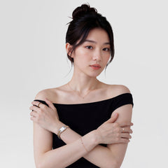 A woman wearing the Daniel Wellington Bound Mini 3-Link Two Tone Rose Gold watch on her wrist, styled with a black off-shoulder top and delicate rose gold jewellery for a refined, modern look.