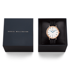 Classic Roman Numerals Date Black Croc Belly Rose Gold watch presented in a Daniel Wellington gift box, showing the rose gold case, white dial with Roman numerals, blue hands, and black croc-embossed leather strap.
