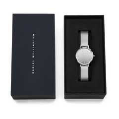 Daniel Wellington Petite Reflection Silver ladies watch with a mirror-finish dial and mesh strap, elegantly presented in a black gift box with the brand name on the lid.