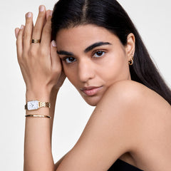 Quadro Roman Numerals 5-Link Gold ladies watch styled on the wrist with gold jewellery, showing its rectangular white dial, Roman numerals, and slim gold bracelet for a polished, elegant look.