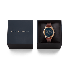 Iconic Chronograph St Mawes Arctic Rg men's watch with a blue dial, rose gold case, and brown leather strap, presented in a premium Daniel Wellington gift box.