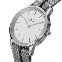 Close-up of the Daniel Wellington Iconic NATO Grey/Black watch showing its minimalist white dial, polished stainless steel case, and textured grey and black NATO strap with a twill weave.