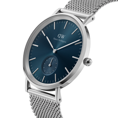 Classic Multi-Eye Sterling Arctic men's watch with a round silver case, deep blue dial, minimalist hour markers, and a stainless steel mesh strap, shown from a side angle to highlight its slim profile and elegant design.