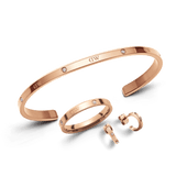 Rose gold Lumine Jewelry Set featuring a minimalist open cuff bracelet, smooth band ring, and dainty earrings, each accented with delicate diamanté details and polished for a refined, elegant finish.