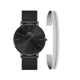 A black mesh strap watch with a minimalist black dial is paired with a slim silver Elan Bracelet engraved with the Daniel Wellington logo, creating a modern and elegant accessory set.