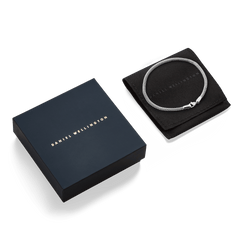 Tide Mesh Bracelet Sterling 2.8 displayed on a black pouch next to a Daniel Wellington gift box, highlighting its elegant silver mesh design and stylish packaging for gifting or personal use.