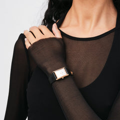 Bound Black Crocodile Rose Gold watch worn on the wrist, showcasing its rectangular rose gold case and crocodile-embossed black leather strap paired with a sheer black top for a modern, elegant look.