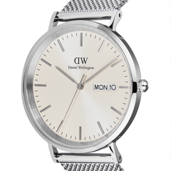 Close-up of the Classic Day Display Sterling Champagne watch showing the champagne dial with a subtle triangle pattern, silver hour markers, and a clear day and date display, paired with a stainless steel mesh strap.