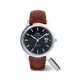 Daniel Wellington Iconic St Mawes Automatic men's watch with a deep blue dial, silver detailing, and brown leather strap, paired with the Elan Ring Silver featuring a polished finish and engraved branding.