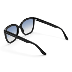 Grande Bio-Acetate Black Blue sunglasses with a classic black acetate frame, blue gradient lenses, and Daniel Wellington branding on the arm, shown from a rear angle to highlight the ergonomic fit and stylish design.
