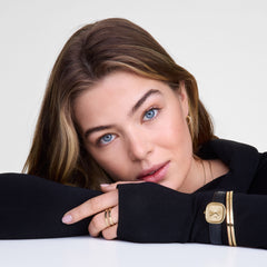 Margot Sheffield Unitone Sunray Gold ladies watch with a rectangular gold case and minimalist gold dial, styled on a wrist with a black leather strap and gold jewellery, suitable for everyday and festive occasions.