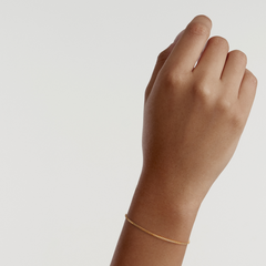 Box Chain Bracelet G worn on a wrist, showcasing its delicate gold finish and classic box chain design, ideal for everyday elegance and comfortable layering.