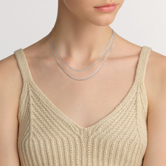 Flat Chain Necklace S styled as a layered silver necklace, worn with a beige knitted top for a minimalist and elegant everyday look.
