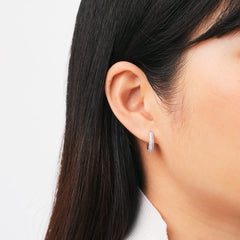 Pavé Crystal Earrings Silver worn on the ear, showcasing the petite hoop design and sparkling cubic zirconia crystals for a refined, elegant look suitable for everyday or special occasions.