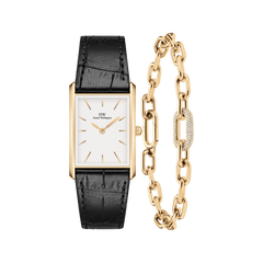 Rectangular gold watch with a white dial and black crocodile-embossed leather strap, paired with a gold chain-link bracelet featuring a pavé crystal accent and polished finish.