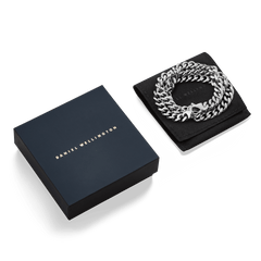 Ellipse Cuban Chain Necklace Silver presented coiled on a black pouch next to an elegant Daniel Wellington gift box, highlighting its chunky silver links and polished finish.