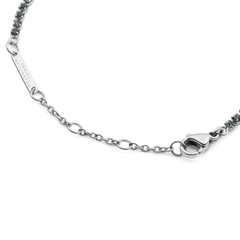Detail of the Classic Tennis Bracelet Nightfall Silver showing the polished silver chain, secure lobster clasp, and individually set dark Preciosa crystals, with the Daniel Wellington logo engraved on the tag.