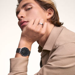A man wearing the Classic Piano Link Onyx Silver watch, featuring a brushed black dial and geometric silver piano link strap, styled with a beige shirt for a modern, everyday look.