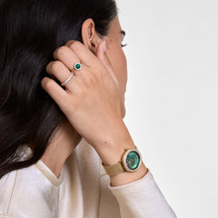 A woman wearing the Pavé Crystal Ring Silver Set, showcasing two slim silver rings with pavé-set crystals stacked together, styled alongside a gold watch and an emerald ring for a modern, elegant look.