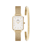 Rectangular gold mesh strap watch with a white face and gold accents, paired with a slim gold cuff bracelet engraved with the Daniel Wellington logo, shown as a stylish women’s jewellery set.