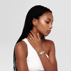 A woman wearing the Arch Earring Gold 9mm, styled with a gold watch and rings, showcasing the petite gold hoop earring’s minimalist design and close fit for everyday wear.