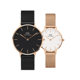 Daniel Wellington Petite Melrose + Petite Ashfield bundle featuring two mesh strap watches for women, one with a black dial and black mesh strap, and the other with a white dial and rose gold mesh strap, both with slim rose gold cases and minimalist design.