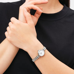 A woman wearing the Elan Lumine Silver ladies watch, featuring a petite stainless steel bracelet and minimalist white dial with crystal markers, styled for everyday elegance.