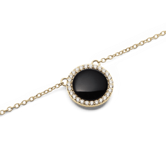 Close-up of the Audrey Necklace Black Agathe Gold showing a domed black agate pendant surrounded by a halo of white cubic zirconia crystals on a fine gold chain.