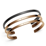 Classic Bracelet Black + 2 Rose Gold set featuring three minimalist stainless steel cuff bracelets, one in matte black and two in polished rose gold, each engraved with Daniel Wellington branding.