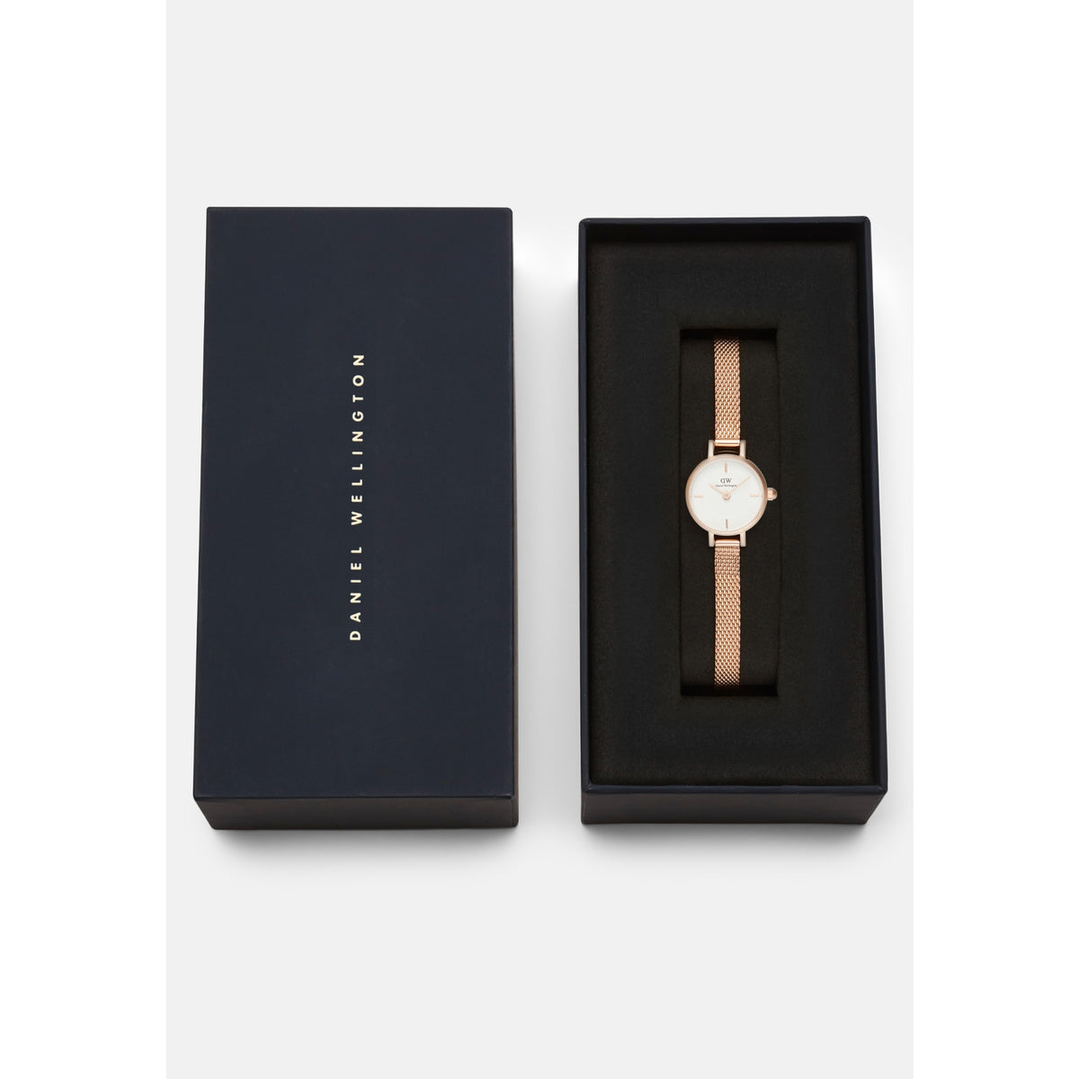 Petite Mini Melrose ladies watch with a rose gold mesh strap and minimalist white dial, elegantly presented in a black Daniel Wellington gift box.