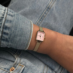 Quadro Mini Evergold Blush gold watch with a blush pink dial and gold mesh strap, worn on a wrist paired with a light blue denim jacket for a casual, stylish look.