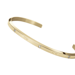 Classic Lumine Bracelet G shown in a curved angle, highlighting its slim gold cuff, polished finish, and six sparkling crystals for a refined, minimalist look.