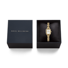 Quadro Mini Arch 3-link White Sunray Gold ladies watch presented in a black Daniel Wellington gift box, highlighting its gold rectangular case, white sunray dial, and polished 3-link bracelet.