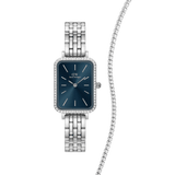 Rectangular Daniel Wellington Quadro Bezel Arctic watch with a polished silver link strap, deep blue dial and crystal-set bezel, paired with a classic silver tennis bracelet featuring a row of sparkling stones.