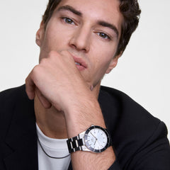 A man wearing the Tide Mesh Necklace Graphite 2.8 styled with a white T-shirt and black blazer, showcasing the necklace’s minimal graphite mesh chain and modern, versatile look.