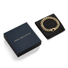 Ellipse Cuban Chain Bracelet Gold displayed on a black pouch next to a Daniel Wellington gift box, highlighting its polished gold links and premium presentation for gifting.
