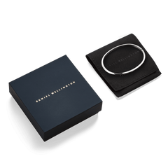 Classic Bangle Silver presented on a black pouch next to a navy Daniel Wellington gift box, highlighting its polished finish and elegant packaging.