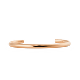 Slim rose gold cuff bracelet with a softly rounded, minimalist design and a polished finish, featuring an open-ended adjustable style suitable for everyday wear.