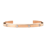 Polished rose gold open cuff bracelet with a minimalist design, featuring eight flush-set cubic zirconia crystals evenly spaced along the band.