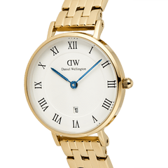 Close-up of the Petite Roman Numerals Date 5-link Gold watch showing the gold 5-link bracelet, white guilloché dial, Roman numeral hour markers, blue hands, and date window at 6 o’clock.
