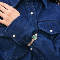 Elan Lumine Malachite Rose Gold ladies watch with a slim rose gold bracelet and green malachite dial, worn with a blue denim shirt for a stylish, casual look.