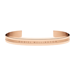 Elan Bracelet Rose Gold by Daniel Wellington with a polished rose gold finish, minimalist open cuff design, and engraved logo, crafted from stainless steel and suitable for layering with other jewellery.
