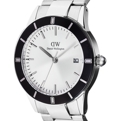 Close-up of the Daniel Wellington Iconic Paradigma Link Black Bezel watch, highlighting its silver dial, bold black bezel with printed index markings, and stainless steel bracelet with polished and brushed links.