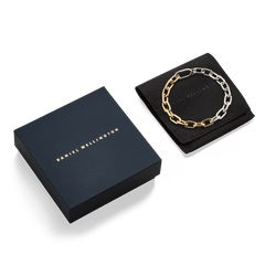 Contrast Link Bracelet Two Tone Gold displayed on a black pouch next to a Daniel Wellington gift box, highlighting its polished gold and silver chain links and elegant packaging.