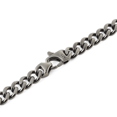 Detail of the Ellipse Cuban Chain Necklace Graphite showing the robust lobster clasp and chunky Cuban links in a matte graphite finish.