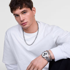A man wearing the Iconic Chronograph Arch 5-Link Off-White Panda Silver watch, styled with a matching silver chain bracelet and necklace, paired with a white long-sleeve shirt for a modern, casual look.