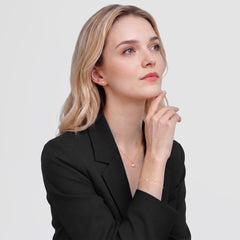 A woman wearing the Pearl Bracelet Gold, featuring alternating white Swarovski glass pearls and cubic zirconia stones on a slim gold chain, styled with a black blazer for a sophisticated, modern look.