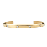 Slim gold cuff bracelet with a polished finish, featuring eight evenly spaced cubic zirconia stones set along the band for a refined and elegant look.