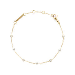 Slim gold chain bracelet featuring alternating white Swarovski glass pearls and cubic zirconia stones, with an adjustable clasp for a comfortable fit.