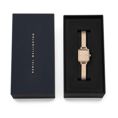 Quadro Mini Reflection Rose Gold ladies watch with a slim rectangular case and rose gold mesh strap, presented in a black Daniel Wellington gift box.